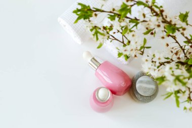 Pembe cam kaplarda yüz serumları. Krem, doğal kaplıca. Boşluğu kopyala