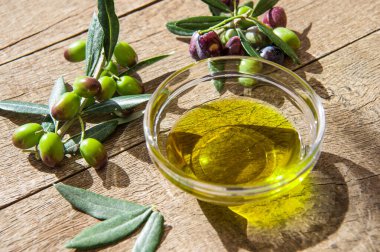 Ekstra zeytinyağı, cam kaplarda şeffaf kaplarda, ahşap arka planda güneş ışığı altında. Sağlıklı Akdeniz yemekleri.