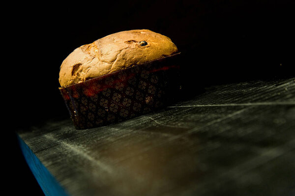the typical Italian Christmas sweet panettone on black wood background