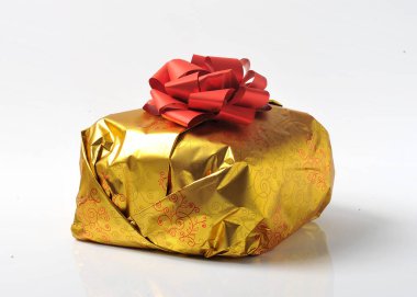 Noel panettone keki kendi altın renkli ambalajında beyaz arka planda izole edilmiş.