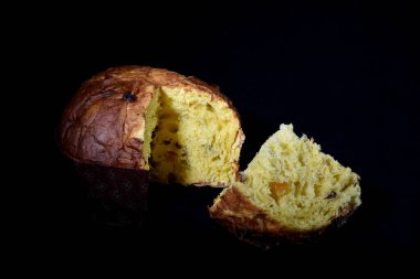 yumuşak ve tatlı zanaatkar İtalyan panettone siyah arka planda dilimlenmiş ve ışık kesiyor
