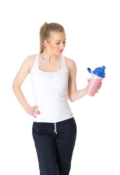 Joven mujer deportiva sosteniendo batido de proteínas — Foto de Stock