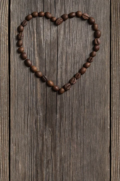 Kawa w kształcie serca na tle drewniane — Zdjęcie stockowe