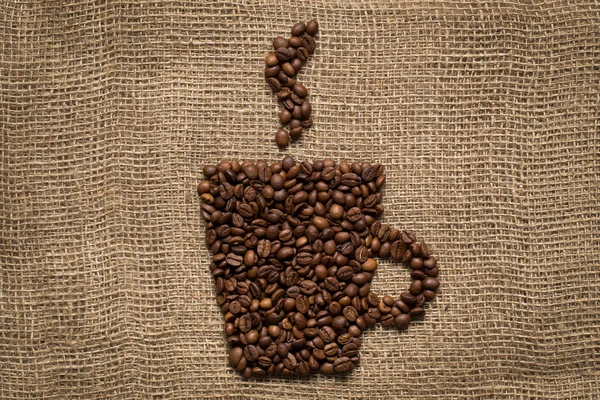 Coffee mug made from roasted beans with anise stars on burlap background — Stock Photo, Image