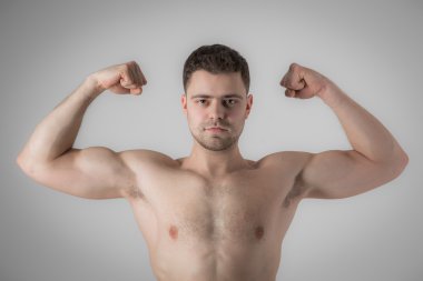 Onun kas veya pazı gösterilen genç adam vücut geliştirmeci