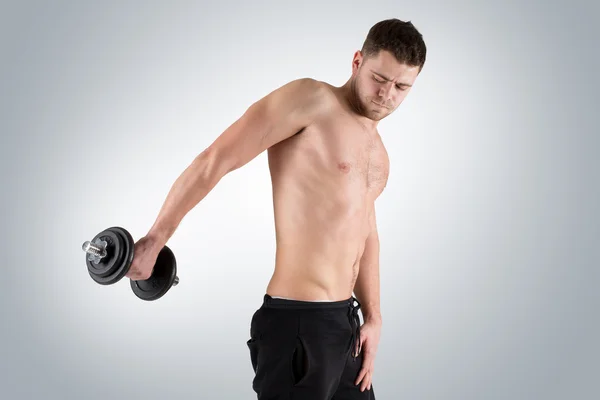 Muskelbodybuilder laver øvelser med håndvægte - Stock-foto