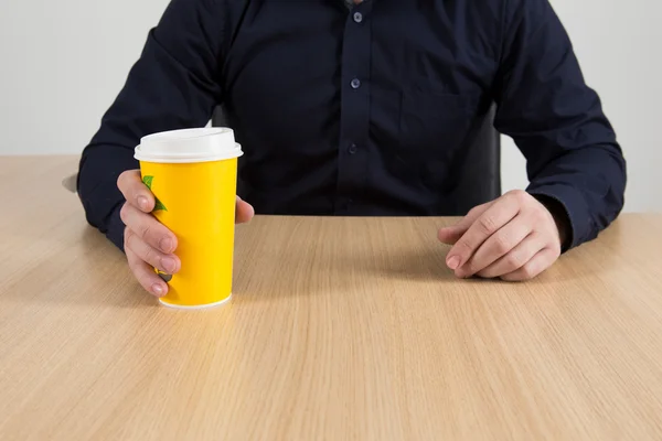 持ったビジネスマンが机に座ってコーヒーを奪う — ストック写真