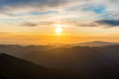 Bir dağ geçidindeki ilk ya da son güneş ışınları. Doğada sabah akşam. Dağ tepelerinde renkli günbatımı ve gün doğumu. Karpatlar yazın ve sonbaharda.