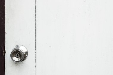 Beyaz ahşap bir kapı üzerinde bir alaşım metal kapı kolu