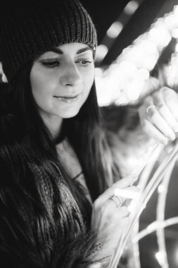 Güzel genç bayan Noel panayırının yanında duruyor. 