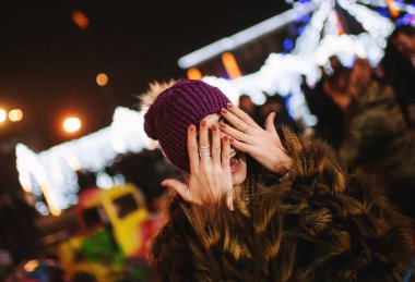 Güzel genç bayan Noel panayırının yanında duruyor. 