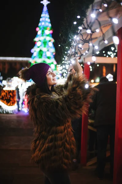 De mooie jongedame die bij de kerstmarkt staat — Stockfoto