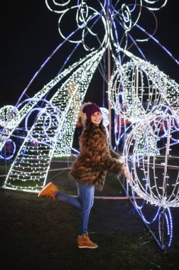 Güzel genç bayan Noel panayırının yanında duruyor. 
