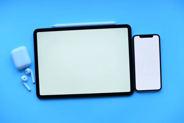 Modelleme. Tablet, telefon kalem ve hava kapsülleri mavi arka planda