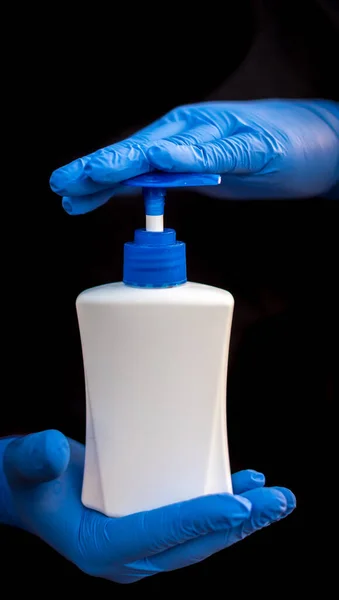 Coronavirus mikrobu koruyucusu ve jel alkolü ya da el dezenfektanı şişesi mavi bir tıbbi eldivenle ellerini yıkamak için.