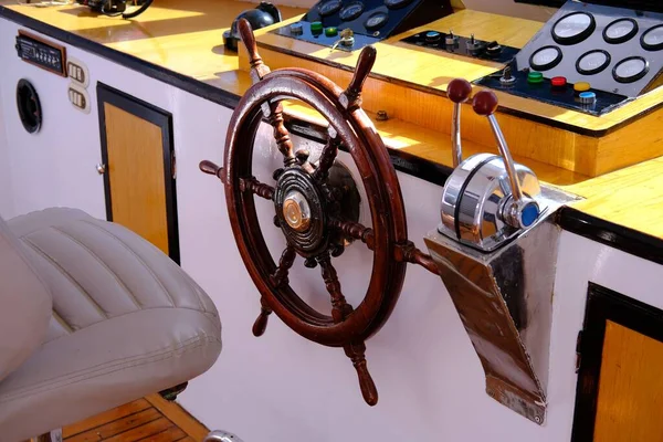 the helm of the yacht.Closeup of a vintage hand wheel on a wooden sailing yacht. Yachting, helm of wooden sailboat in port of sailing, rope, steering wheel, details of yacht