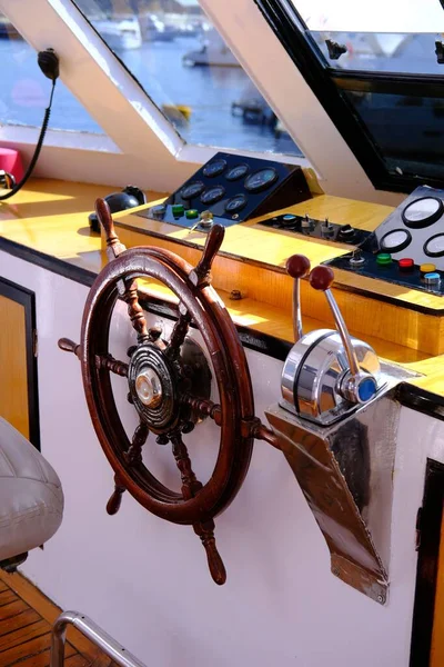 the helm of the yacht.Closeup of a vintage hand wheel on a wooden sailing yacht. Yachting, helm of wooden sailboat in port of sailing, rope, steering wheel, details of yacht