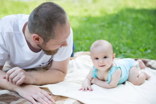 Baby playing with father on the grass — Stock Photo, Image