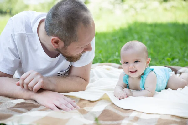 Baby playing with father on the grass — Stock Photo, Image