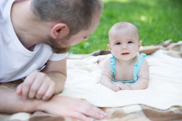 Baby playing with father on the grass — Stock Photo, Image