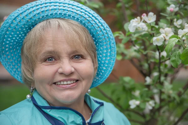 Active senior woman wearing blue hat — Stock Photo, Image