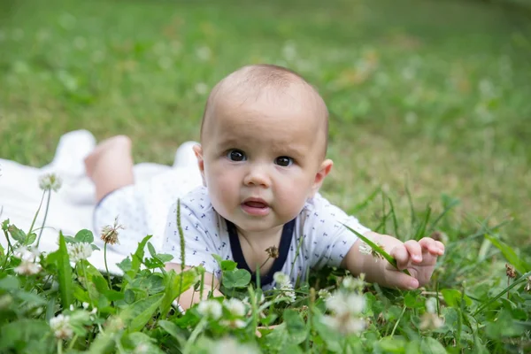 Baby Mädchen kriecht auf dem Gras. Selektive Fokussierung ihrer Augen. — Stockfoto