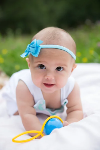 Baby girl crawling on the grass. Selective focus her eyes. Stock Picture