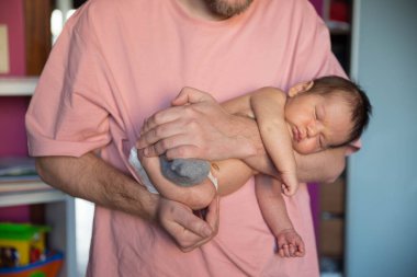 Tatlı bebek yeni doğmuş Baba ellerinde uyuyor