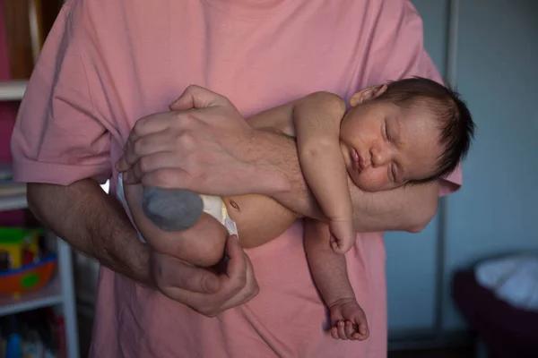 Söt baby nyfödd sova på far händer Stockfoto