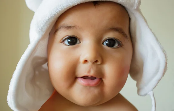 Porträtt av söt glad 4 månader gammal pojke med roliga vit hatt Royaltyfria Stockfoton