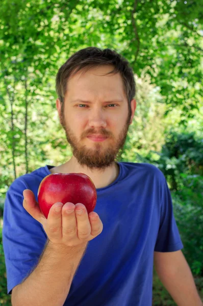 Червоне яблуко на долоні молодого красивого чоловіка — стокове фото