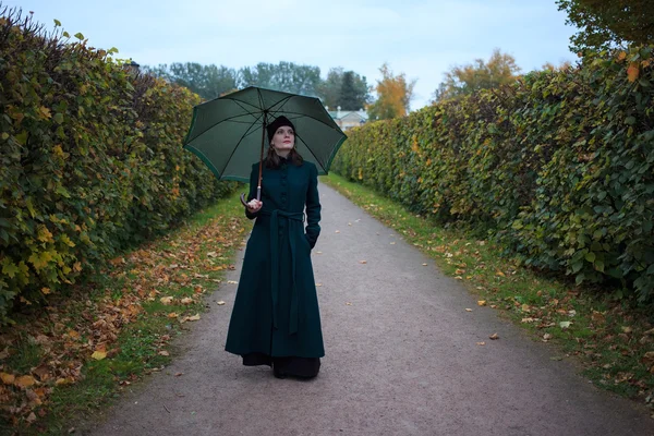 Vacker vintage stil kvinna med paraply i höst park Royaltyfria Stockfoton