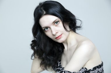 Güzel bir cilt ve gri arka plan üzerinde doğal makyaj göz alıcı genç esmer kadın