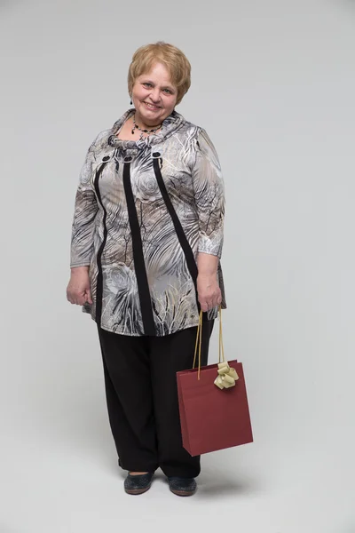 Retrato de una anciana feliz sobre un fondo gris — Foto de Stock