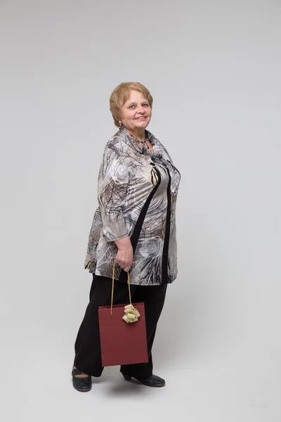 Portrait of an elderly happy woman on a grey background — Stock Photo, Image