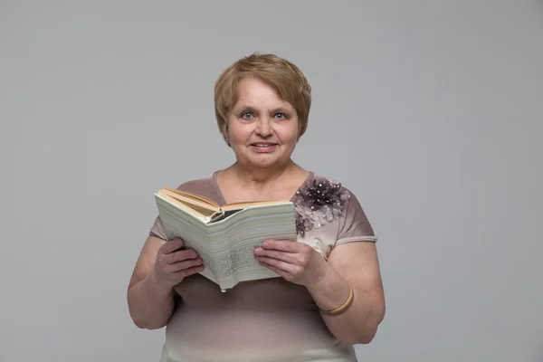 Retrato de mujer mayor sonriente con libro en estudio — Foto de Stock