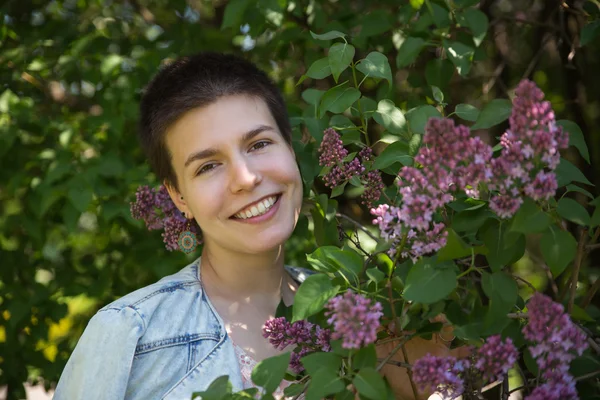 Vacker söt flicka leende under lila träd — Stockfoto