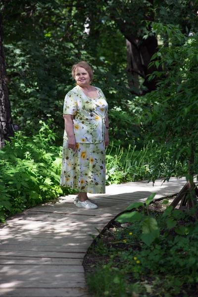Old lady walking in garden — Stock Photo, Image