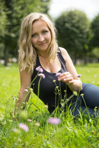 Ung kvinna i grön solig park — Stockfoto