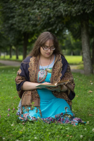 Mujer joven con libro en el verde parque soleado —  Fotos de Stock