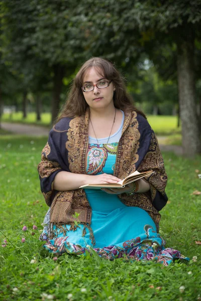 Mujer joven con libro en el verde parque soleado —  Fotos de Stock