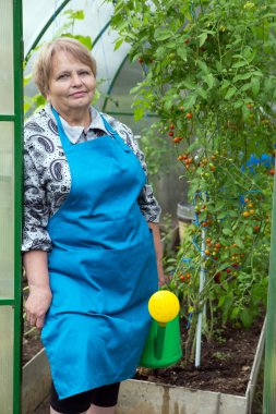 Serada sulama olabilir ile önlük giyen üst düzey emekli kadın