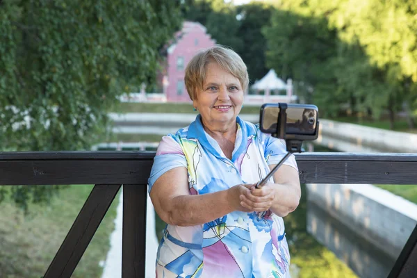 Mujer adulta con monópodo tomando selfie — Foto de Stock