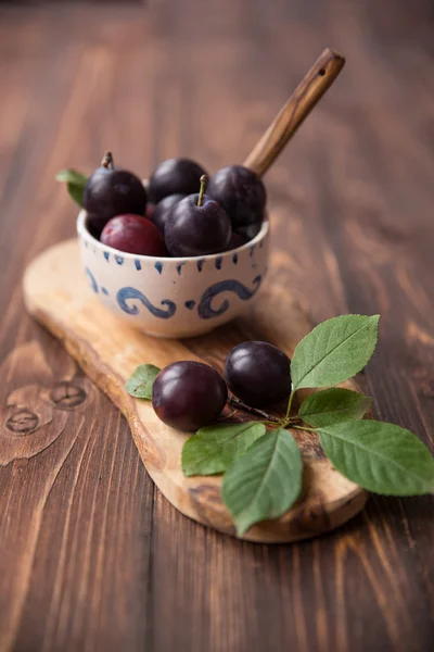 Pruimen met servet op houten tafel — Stockfoto