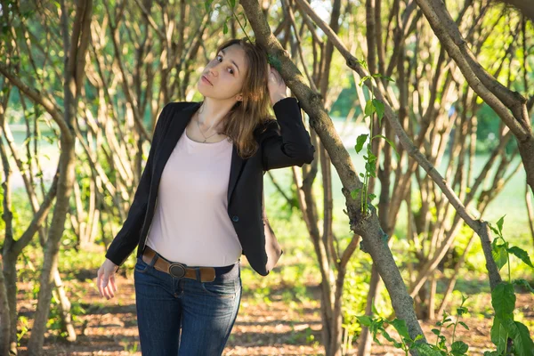 Mujer joven y bonita bajo el árbol en un día soleado y brillante —  Fotos de Stock