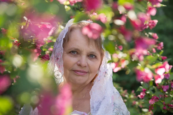 Пенсионерка в цветущем саду — стоковое фото
