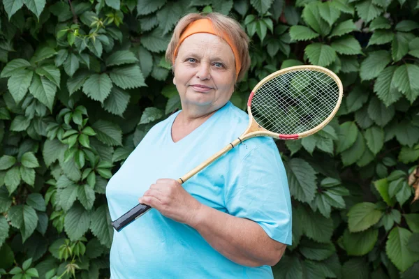 Sportig pensionär kvinna med racket Royaltyfria Stockbilder