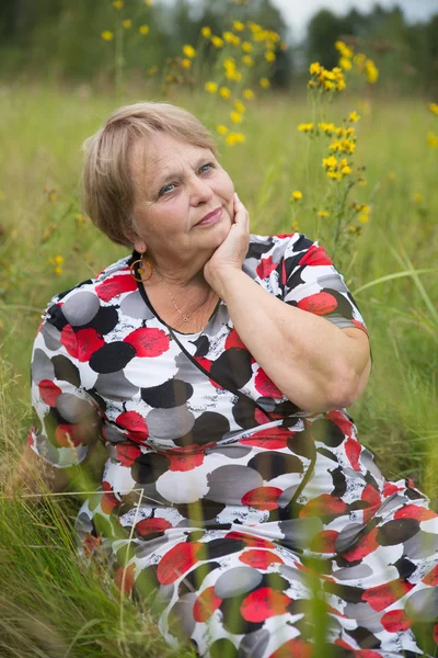 Romantic pensioner woman relax on grass. Selective focus on her face — Stock Photo, Image