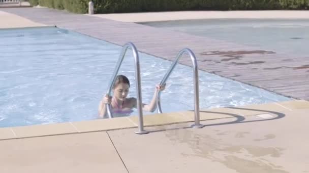 Женщина выходит из бассейна — стоковое видео