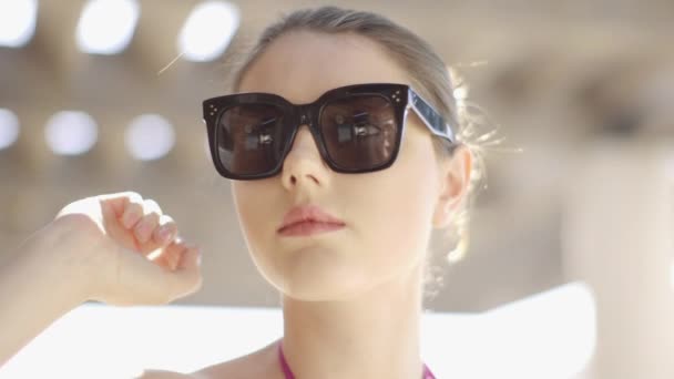 Vrouw zoekt over zonnebril camera — Stockvideo
